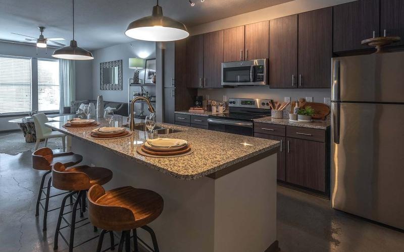 a kitchen with wood cabinets and stainless steel appliances